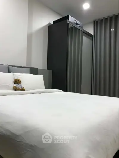 Cozy bedroom with modern wardrobe and plush bedding, perfect for relaxation.