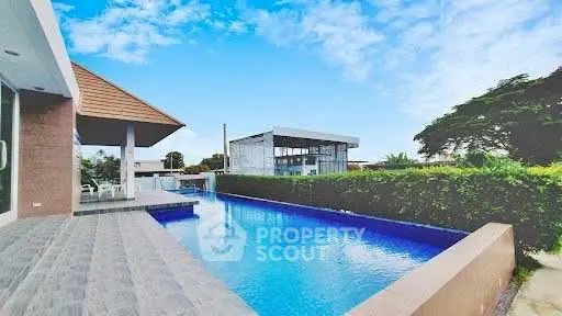 Luxurious property with stunning pool and modern architecture under a clear blue sky.
