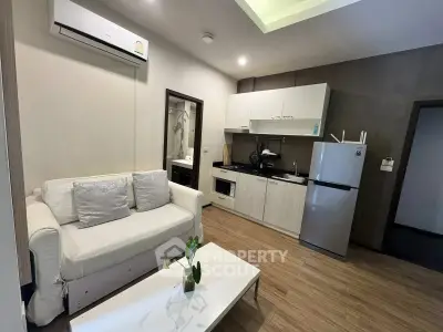 Modern living room with cozy sofa and sleek kitchen in open layout apartment.