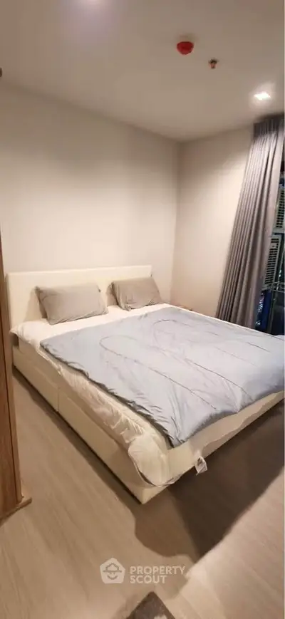 Spacious bedroom with modern decor and large bed in a cozy apartment setting.