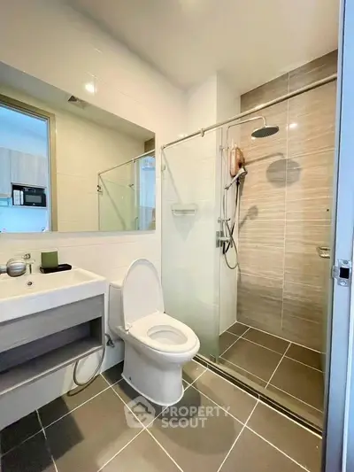 Modern bathroom with glass shower and sleek fixtures in a contemporary apartment.