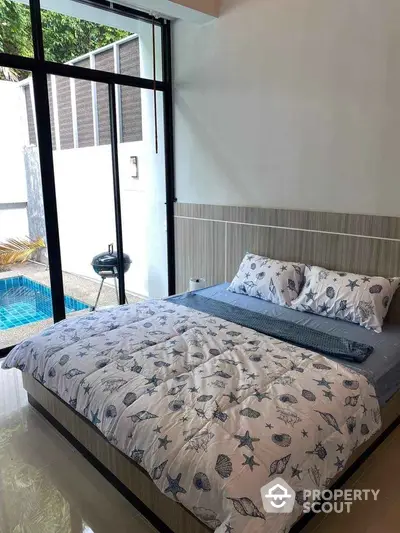 Cozy bedroom with pool view and modern decor, perfect for relaxation and comfort.