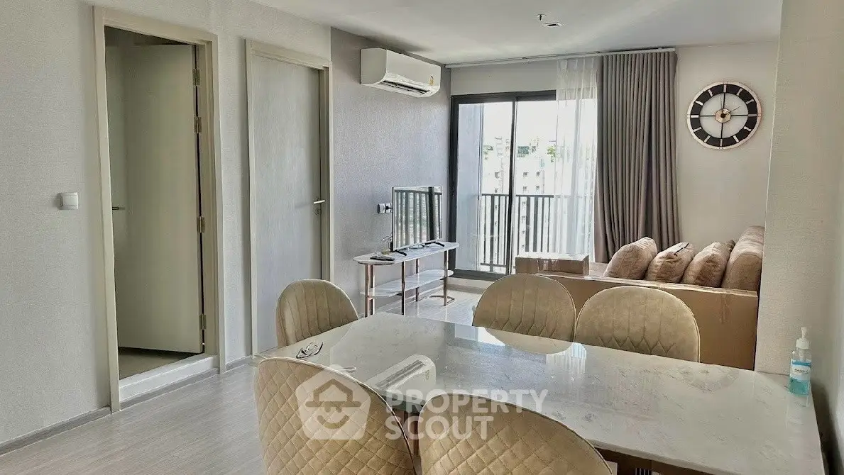 Modern living room with dining area and balcony access in a stylish apartment.