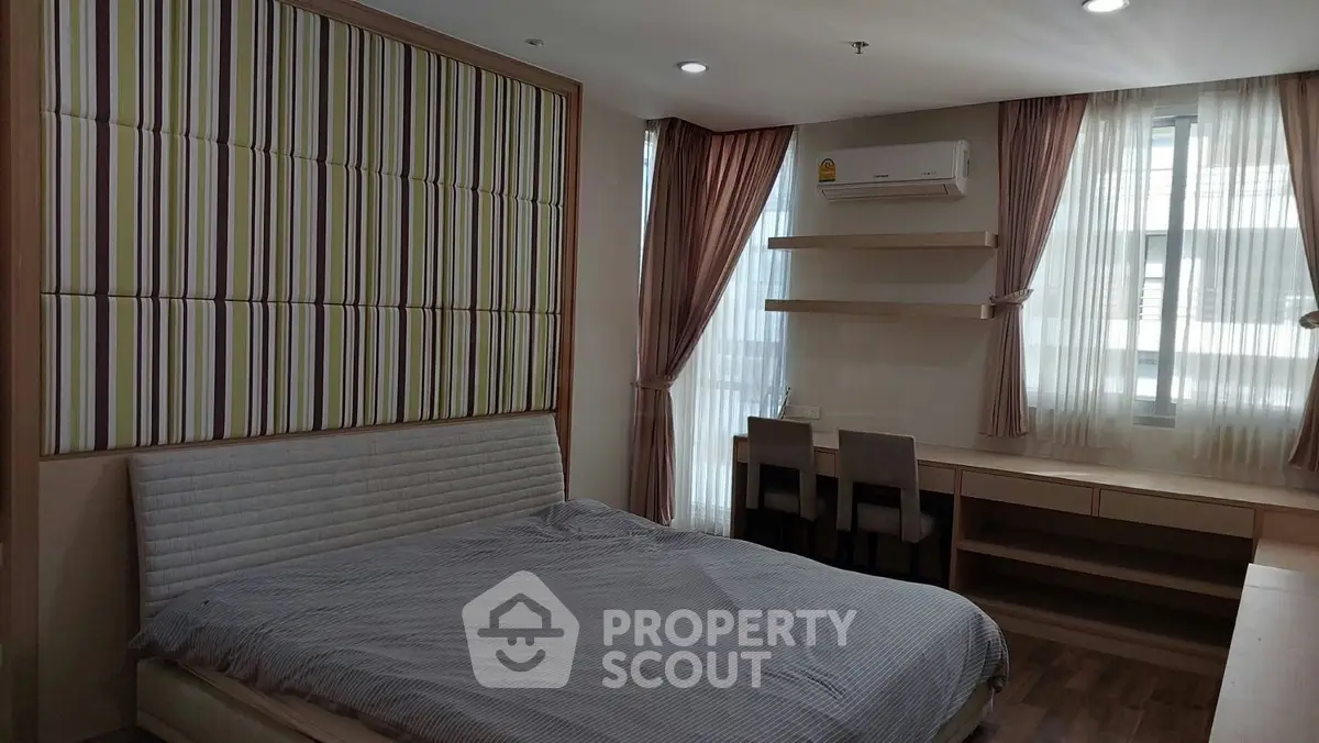 Spacious bedroom with modern decor and ample natural light, featuring a comfortable bed and stylish furnishings.