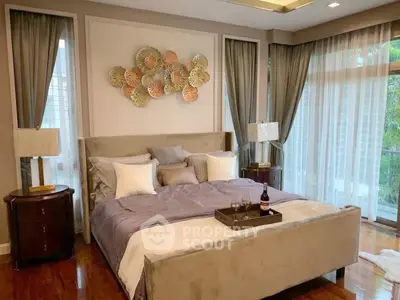 Luxurious bedroom with elegant decor and large windows offering natural light.