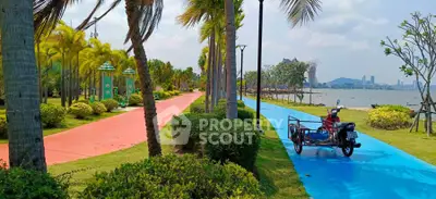 Scenic park pathway with lush greenery and waterfront view
