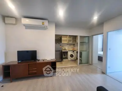 Modern living room with open kitchen and sleek appliances in a stylish apartment.