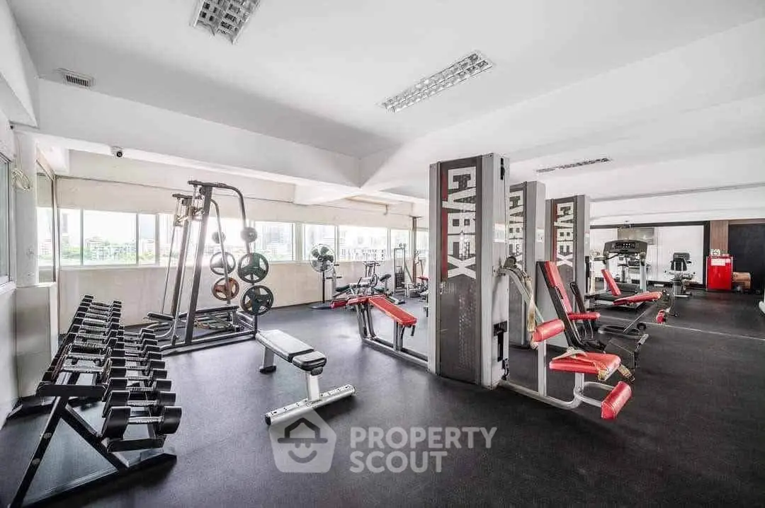 Spacious and well-equipped gym with modern fitness machines and weights, ideal for active lifestyle enthusiasts.