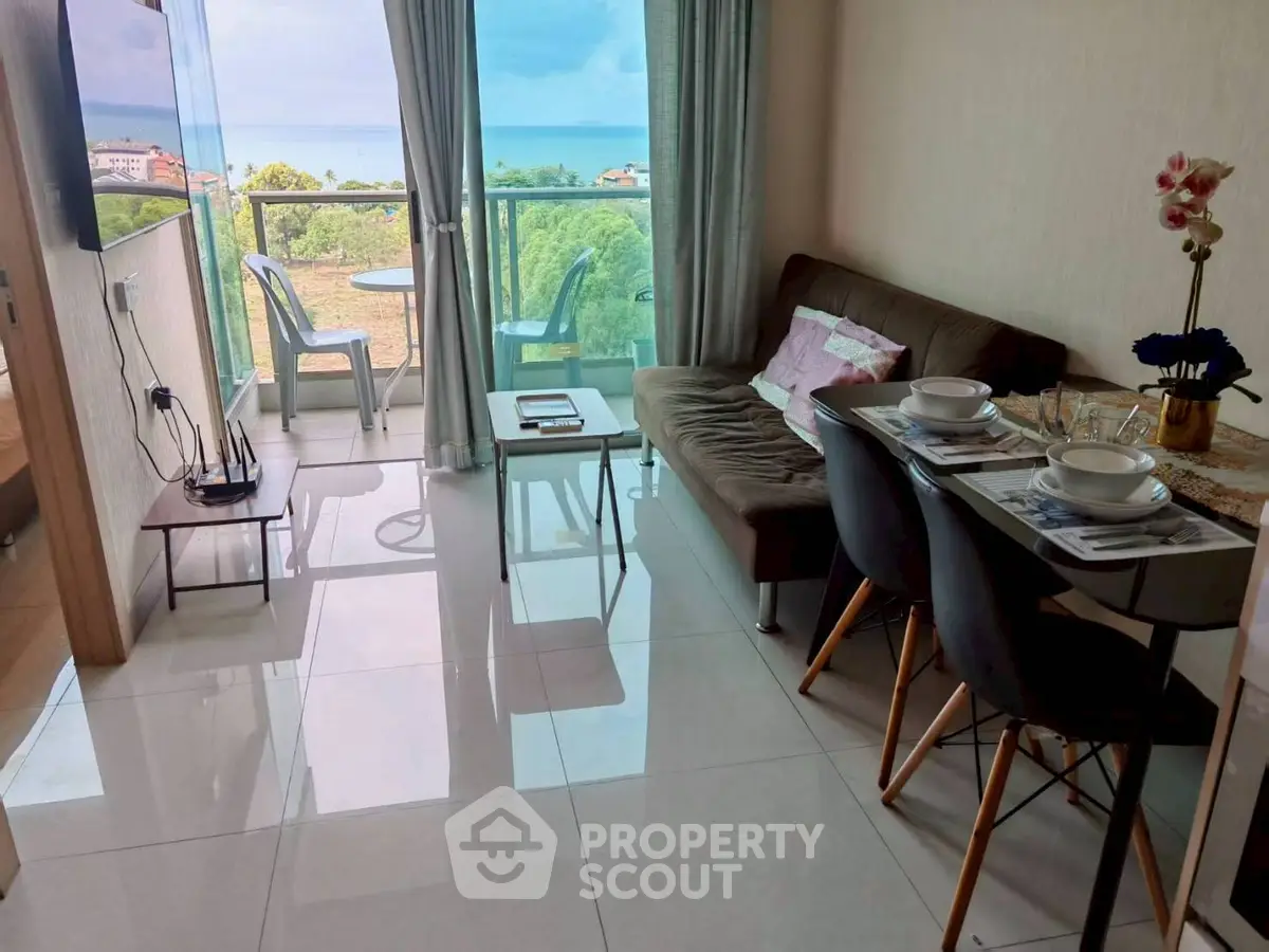 Modern living room with ocean view, sleek furniture, and balcony access in a stylish apartment.