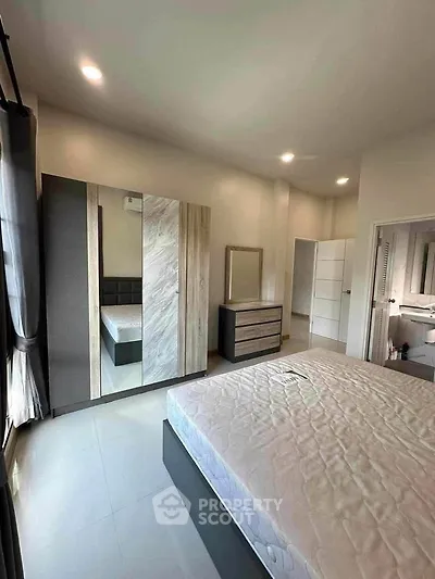 Spacious bedroom with modern furniture and ample natural light
