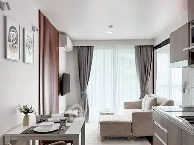 Modern living room with open kitchen, stylish decor, and natural light