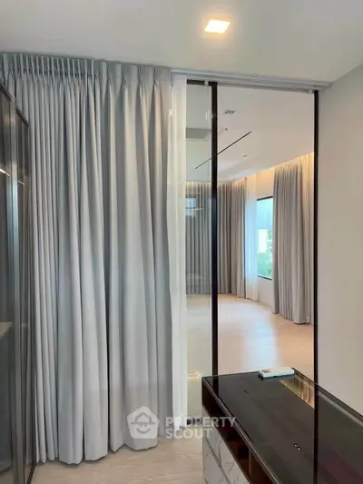 Spacious modern interior with floor-to-ceiling windows and elegant curtains, perfect for natural light lovers.