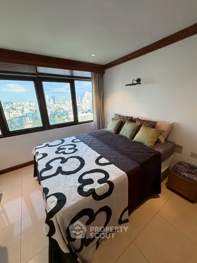 Spacious bedroom with city view, large windows, and modern decor in high-rise apartment.