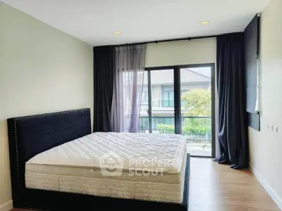 Spacious bedroom with large window and modern decor in a stylish home.