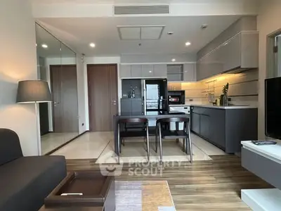 Modern open-layout kitchen and living area with sleek design and natural light.