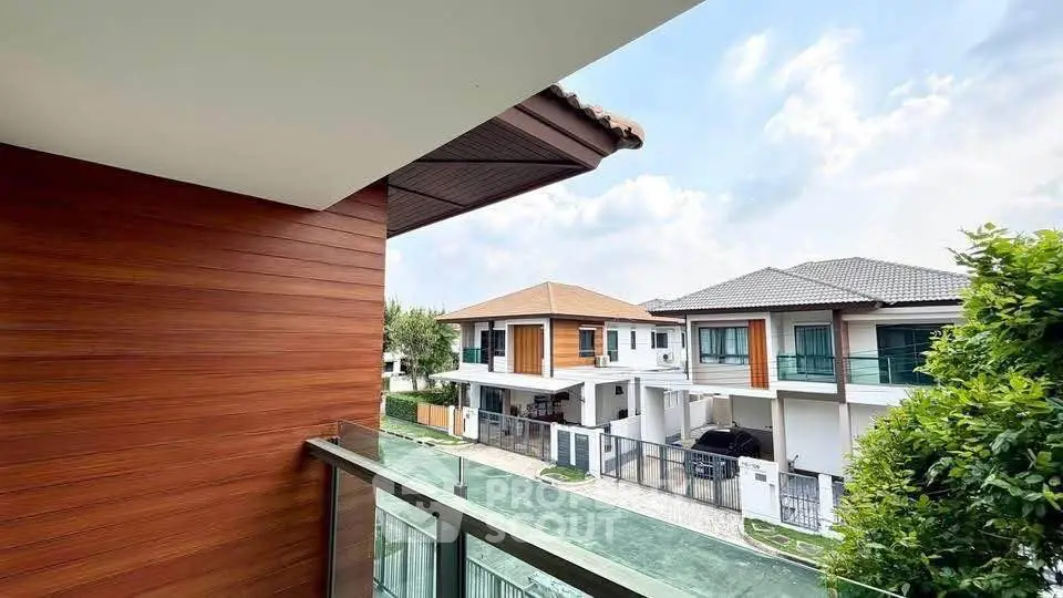 Modern residential neighborhood view from balcony with stylish houses and clear sky.