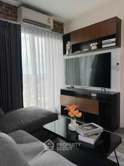 Modern living room with sleek furniture and large TV, perfect for relaxation and entertainment.