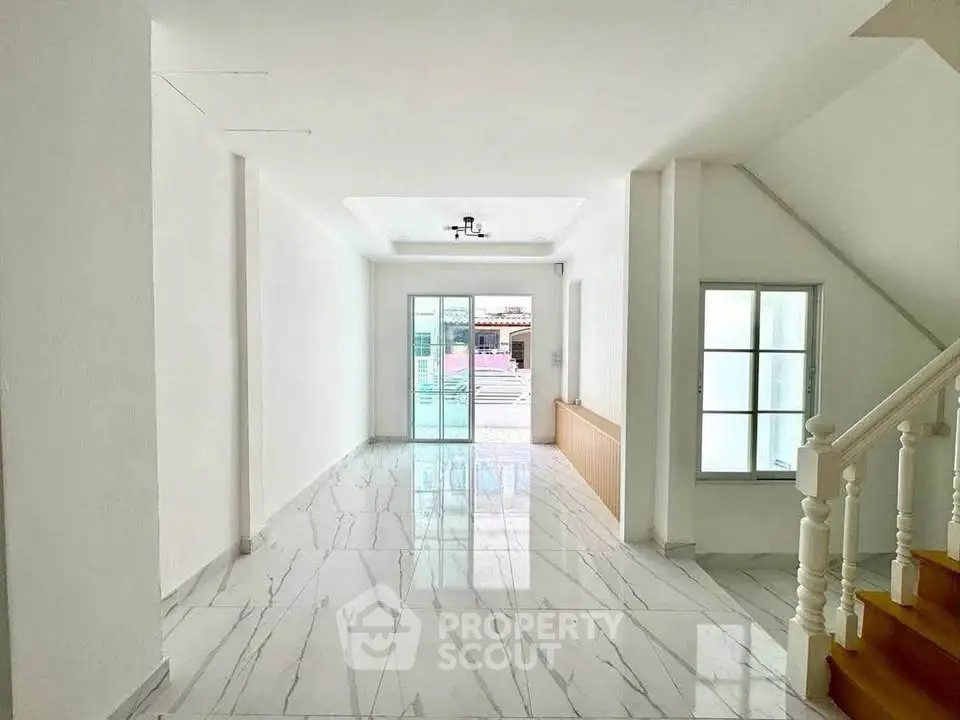 Spacious and bright living room with marble flooring and large windows.