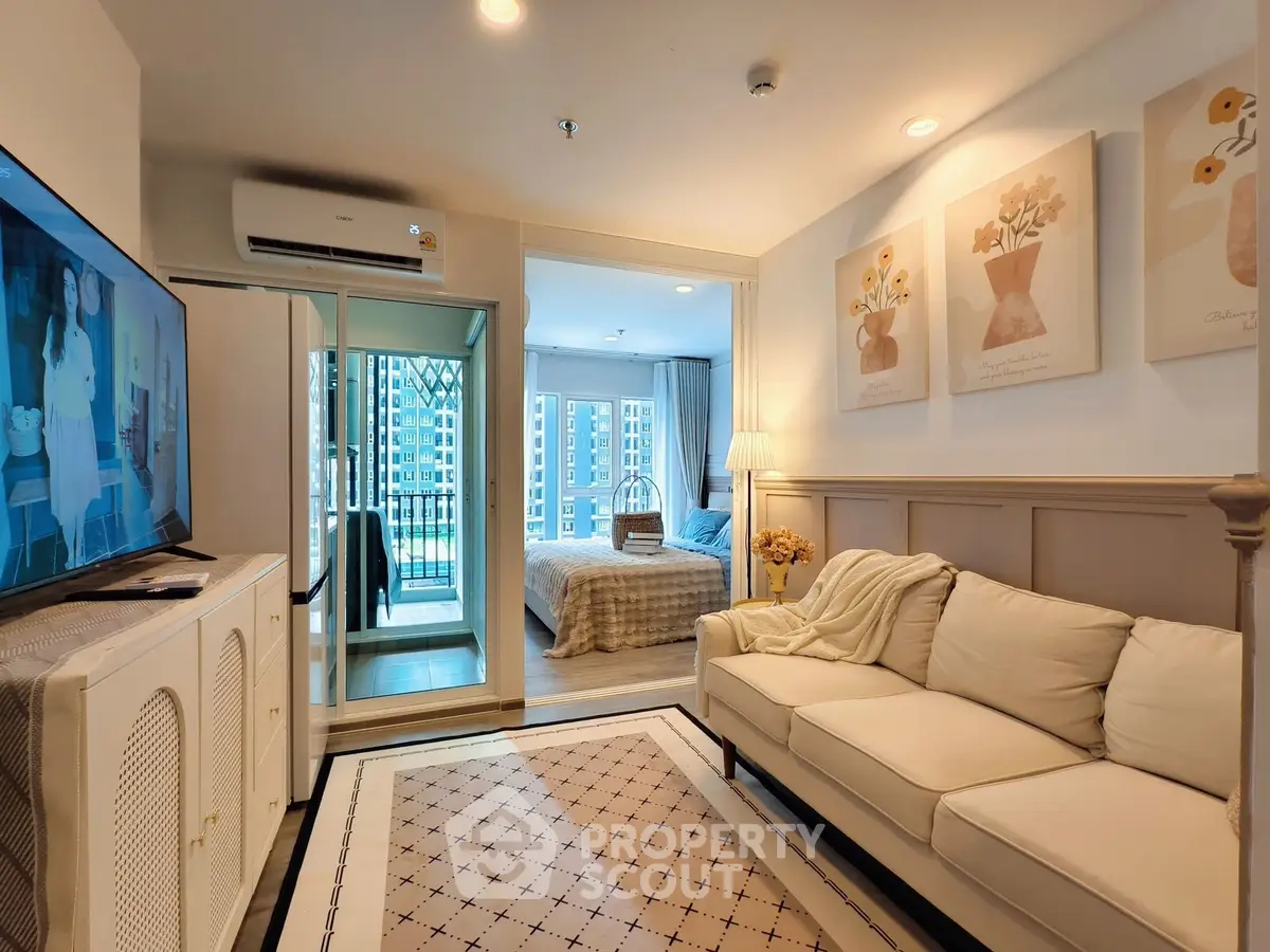 Chic modern living room with cozy sofa and stylish decor, leading to a bright bedroom with balcony view.