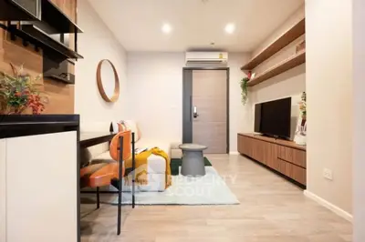 Modern living room with stylish decor and open layout, featuring a cozy seating area and sleek entertainment unit.