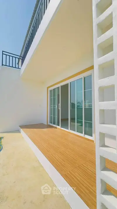 Modern balcony with sliding glass doors and wooden flooring in a contemporary home.