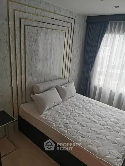 Modern bedroom with elegant decor and large window for natural light