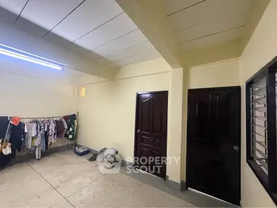 Spacious interior with laundry area and two wooden doors, ideal for practical living.