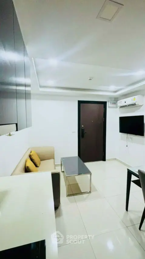 Modern living room with sleek design, featuring a cozy sofa and wall-mounted TV.