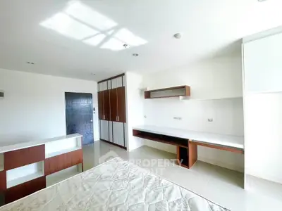 Spacious bedroom with modern built-in furniture and ample natural light