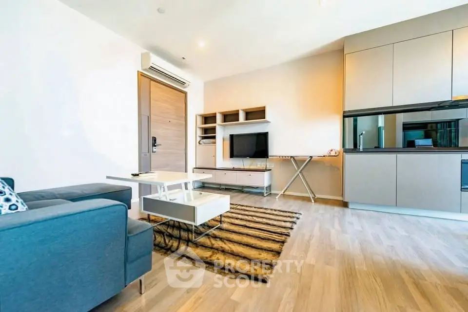 Modern living room with sleek furniture and open kitchen layout in a stylish apartment.