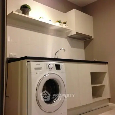 Modern kitchen with washing machine and sleek cabinetry