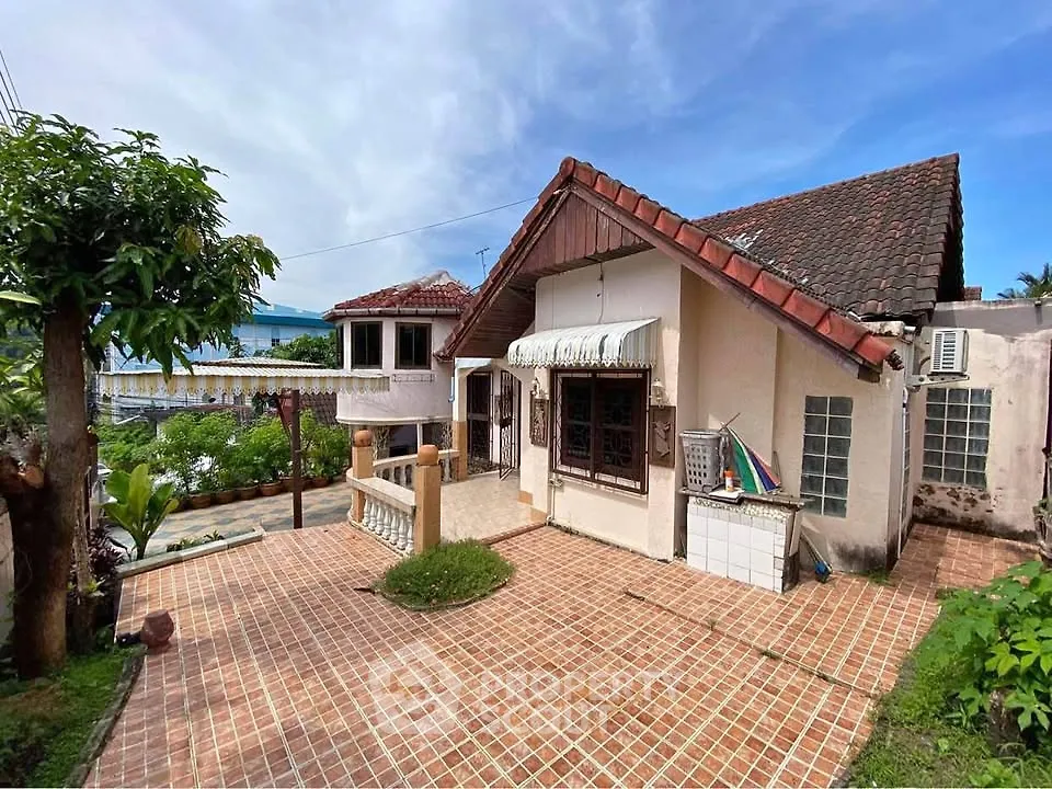 Charming rustic house with tiled roof and spacious outdoor patio in a serene neighborhood.