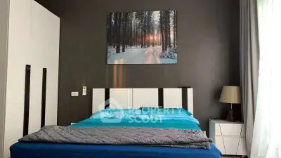 Modern bedroom with stylish decor and natural light, featuring a cozy bed and elegant furnishings.