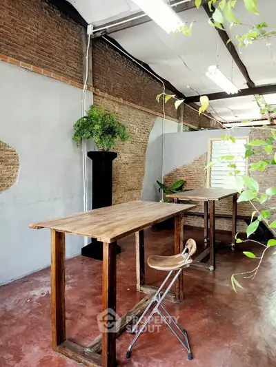 Charming rustic interior with wooden tables and brick walls, perfect for a cozy workspace or studio.