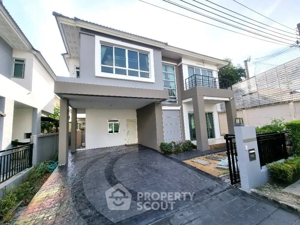 Modern two-story house with spacious driveway and contemporary design.