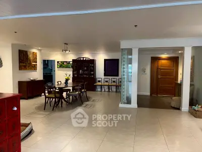 Spacious open-plan living and dining area with elegant wooden furniture and modern decor.