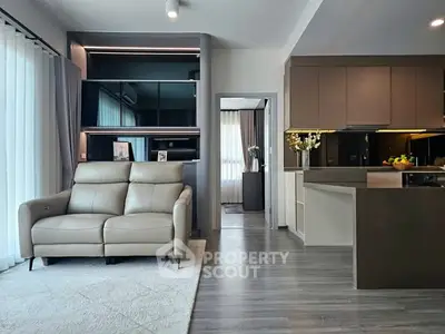 Modern open-plan living room with sleek kitchen and cozy seating area, perfect for urban living.