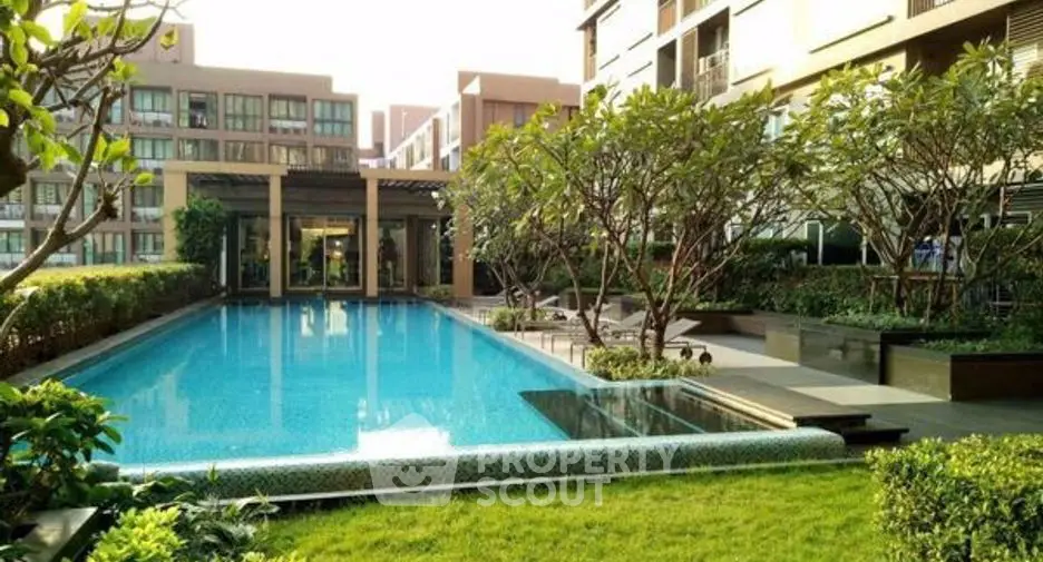 Luxurious residential pool area with lush greenery and modern architecture.