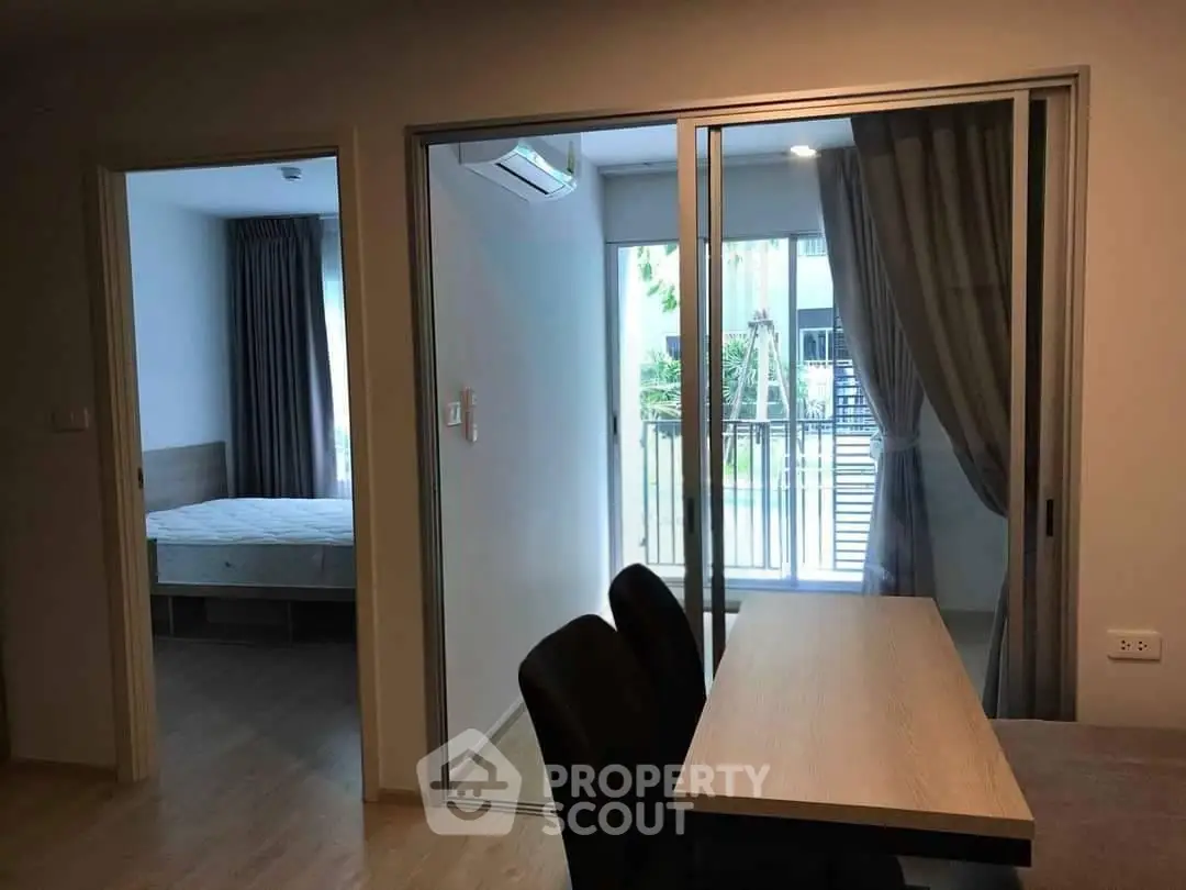Modern apartment interior with sliding glass doors and a view of the balcony.