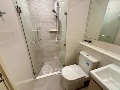 Modern bathroom with glass shower enclosure and sleek fixtures
