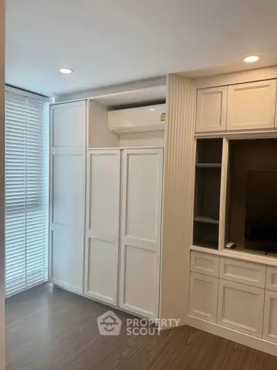 Modern living room with built-in cabinets and air conditioning