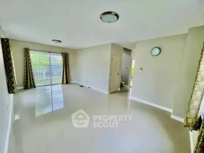 Spacious empty living room with large windows and glossy tiled floors