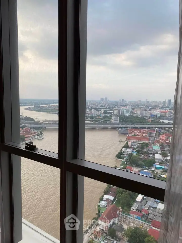Stunning high-rise view of river and cityscape from a modern apartment window.