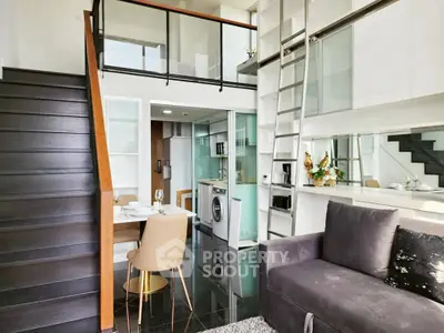 Modern loft apartment with sleek staircase, cozy living area, and compact kitchen featuring washing machine.