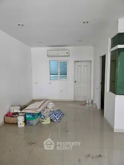 Spacious empty room with air conditioning and tiled floor, ready for customization.