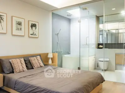 Modern bedroom with ensuite bathroom featuring glass shower and bathtub.