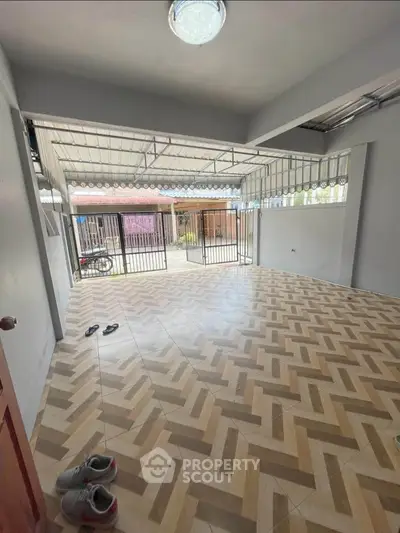 Spacious room with stylish herringbone flooring and large windows for natural light