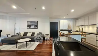 Modern open-layout living room and kitchen with sleek design and stylish furniture.