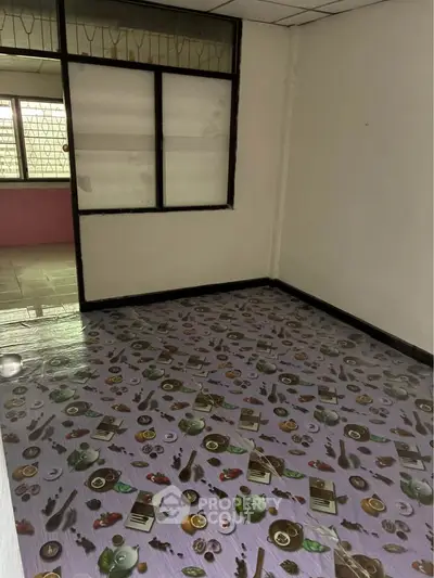 Unfurnished room with unique patterned flooring and large window, ideal for customization.