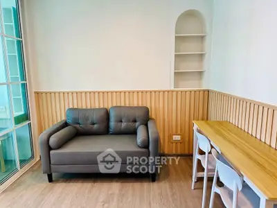 Modern living room with stylish sofa and wooden dining table, perfect for cozy gatherings.